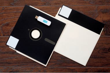An 8-inch floppy disk like the ones used by the automatic management system of the US nuclear arsenal, next to a pendrive